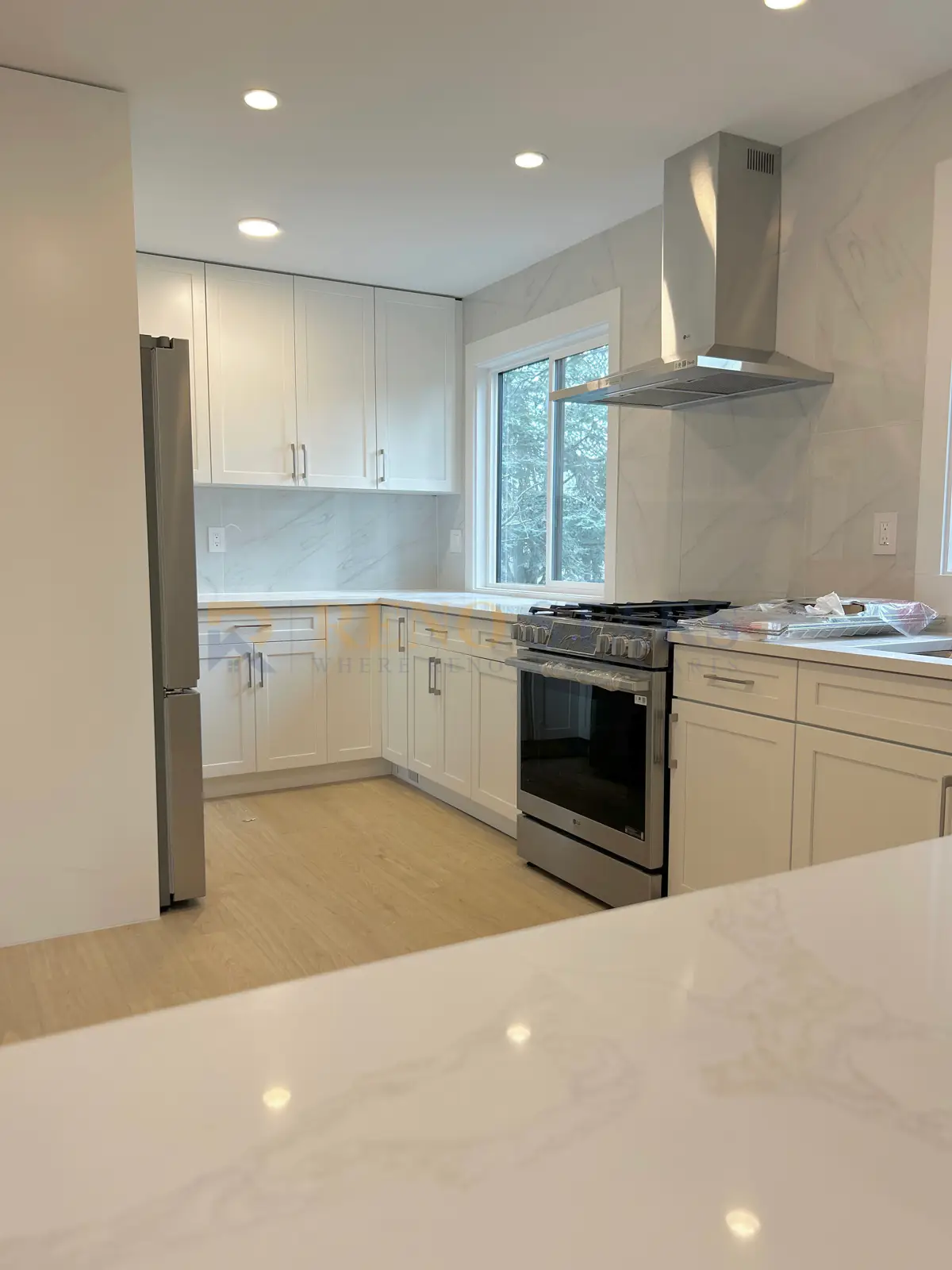 Richmond townhouse kitchen after renovation with white shaker cabinets, quartz countertops and reorganised storage