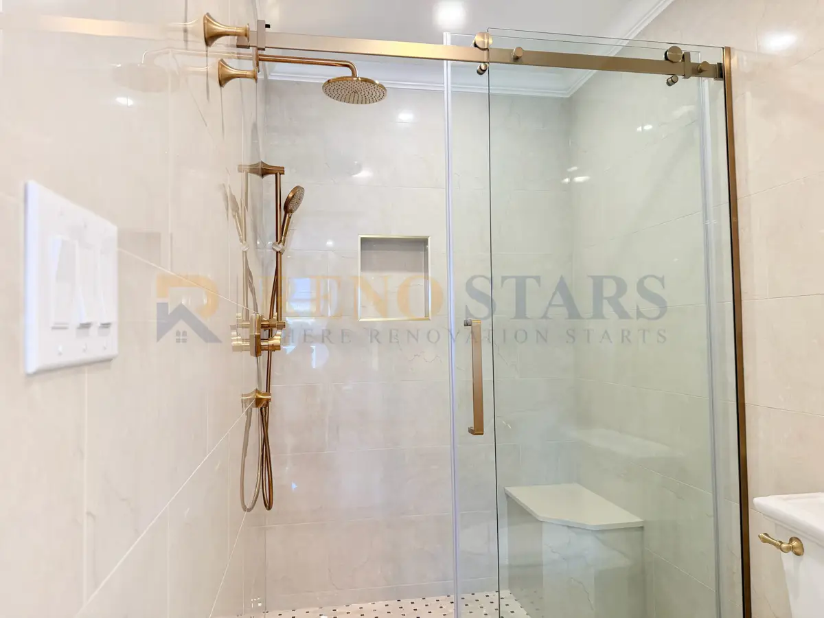 Walk-in shower with frameless glass door and champagne gold rain head in West Vancouver bathroom renovation