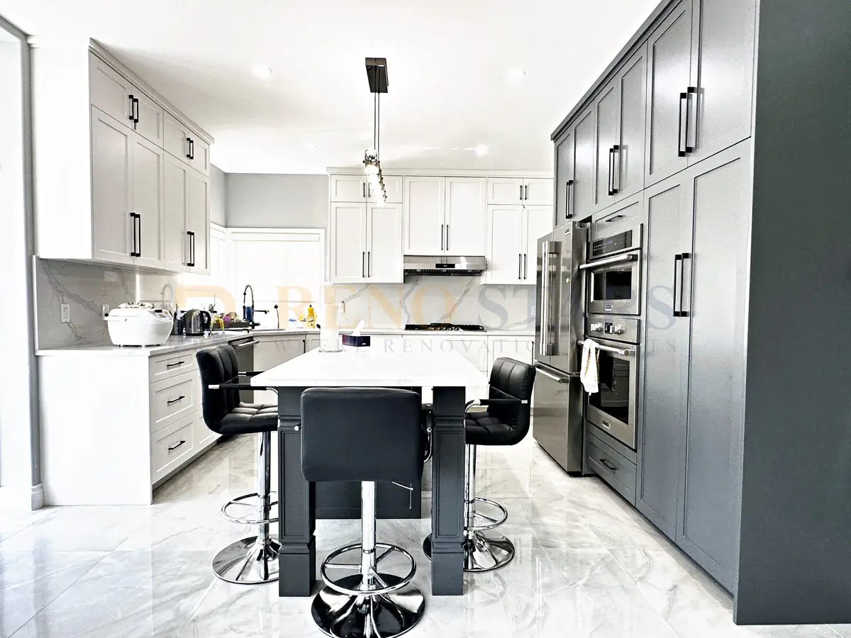 Modern white kitchen with waterfall quartz island, shaker cabinets, and matte black fixtures in Coquitlam home
