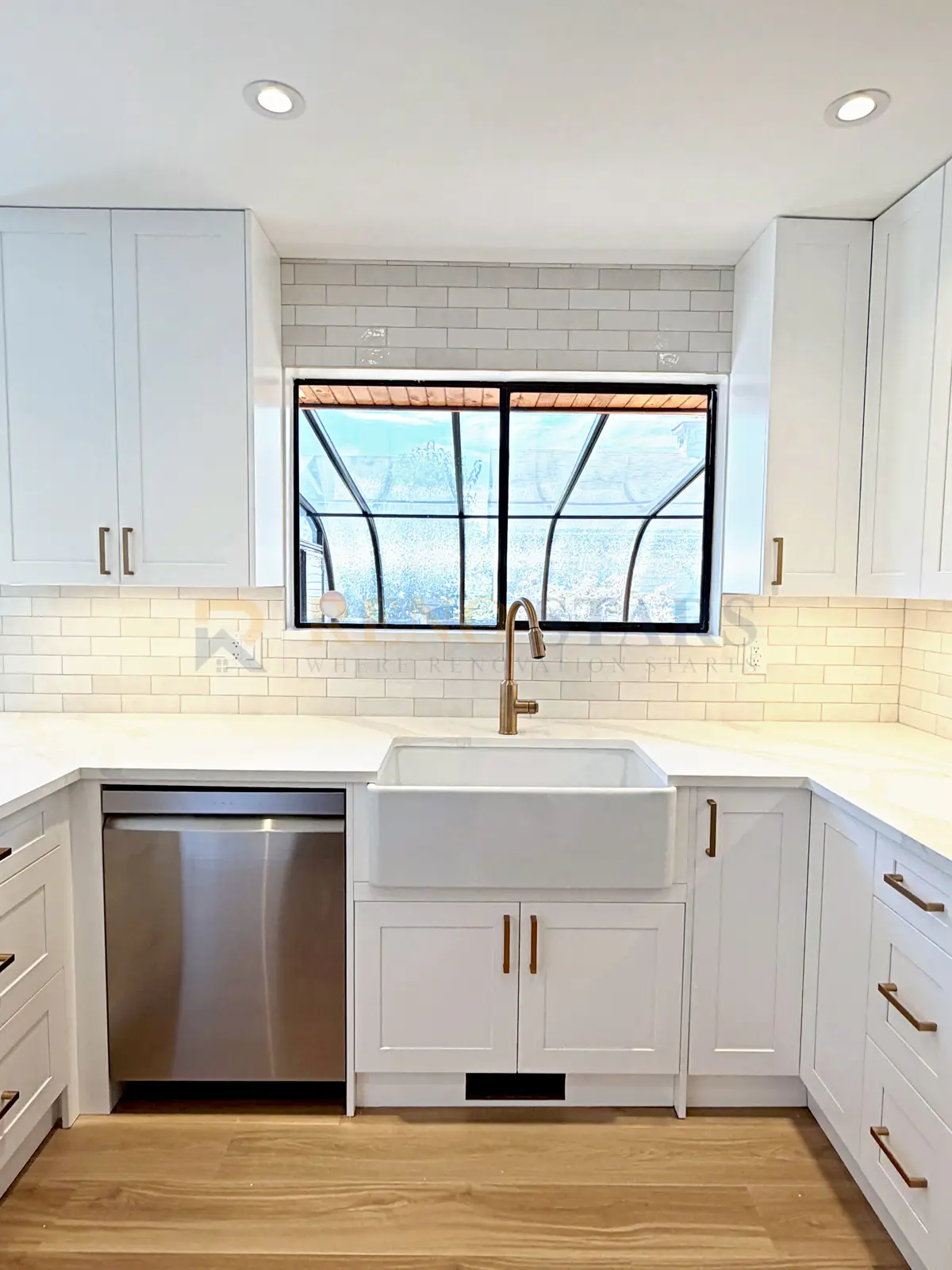 Delta kitchen with apron sink, white quartz waterfall countertop, and new pendant lighting