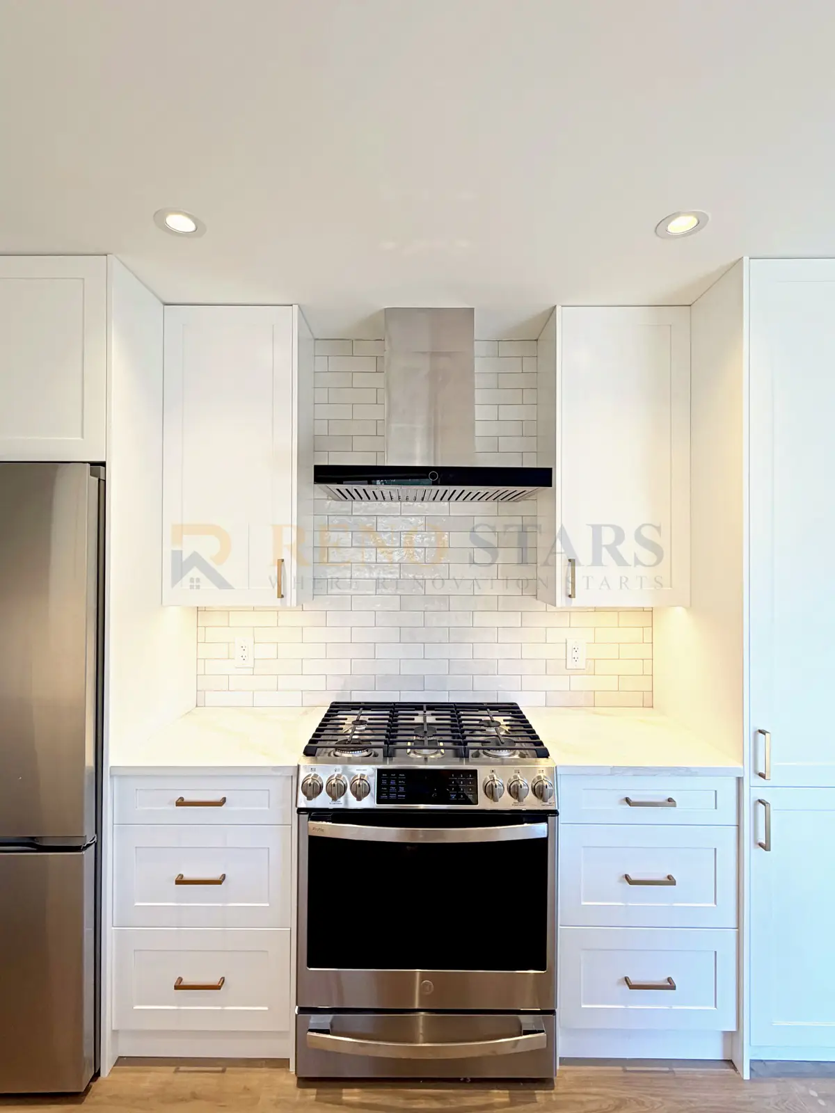 White Shaker kitchen cabinets with quartz waterfall peninsula, brushed brass tapware, Delta BC