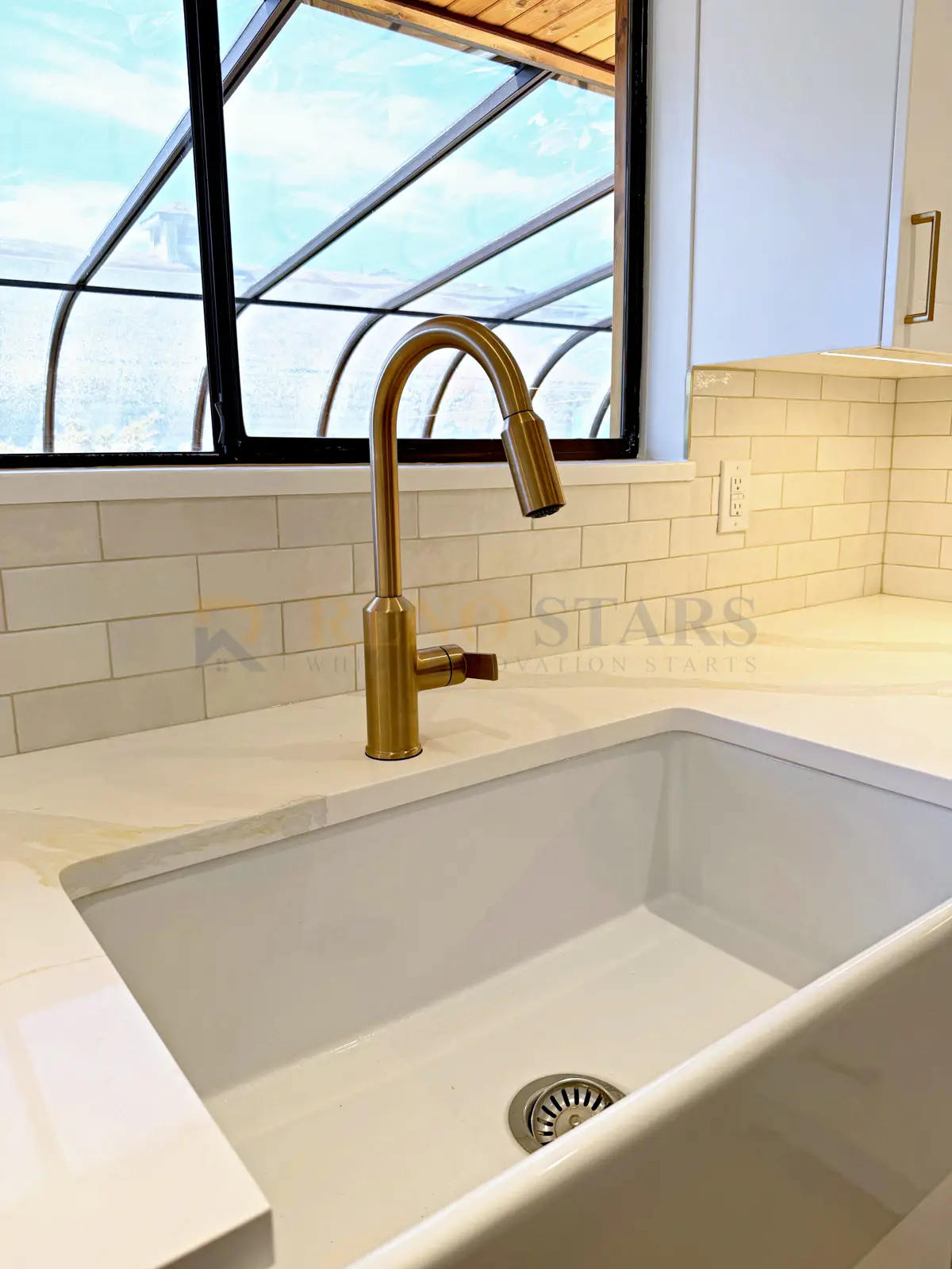 Delta whole-house renovation bathroom — grey vanity, black-framed mirror, marble-look tile