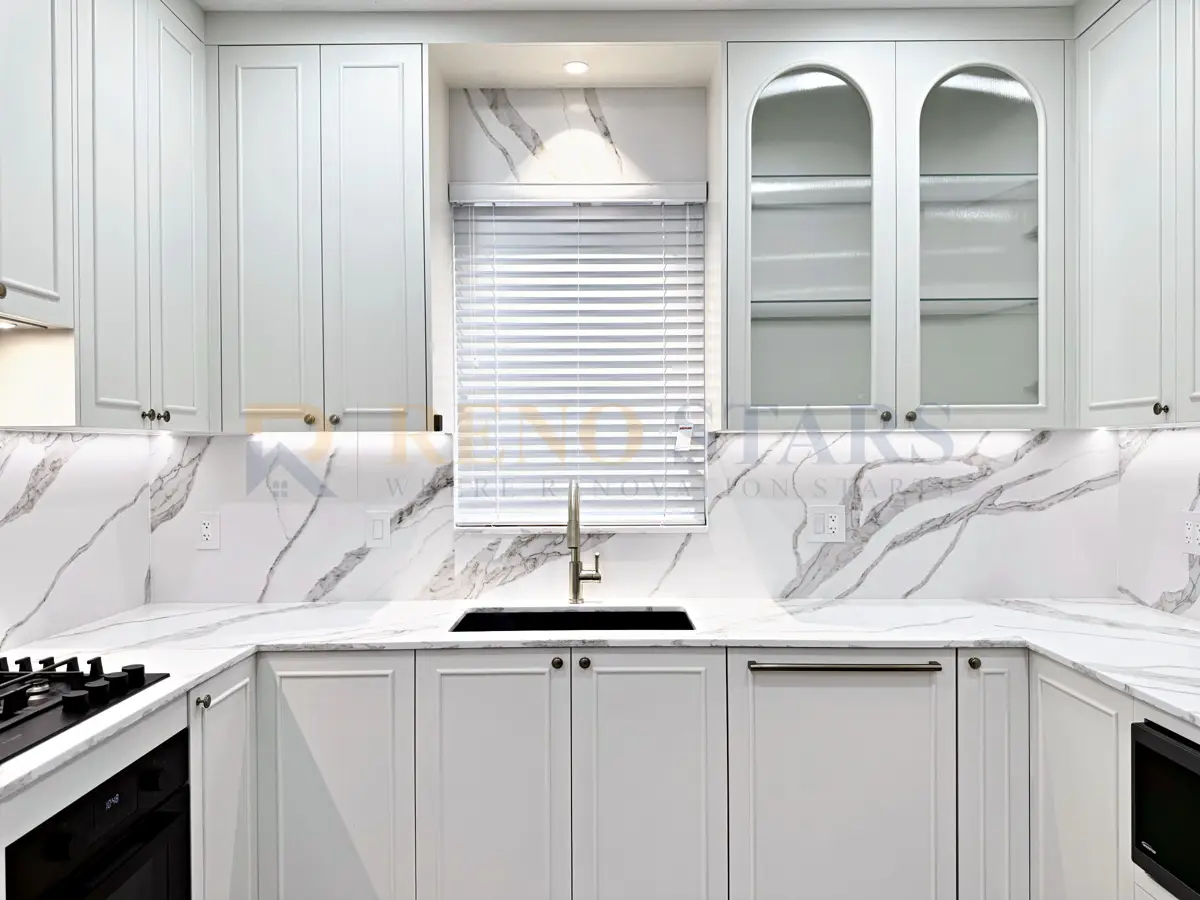 Marble-look kitchen after renovation in Richmond: full-height slab backsplash, arched glass cabinets, brushed gold tapware