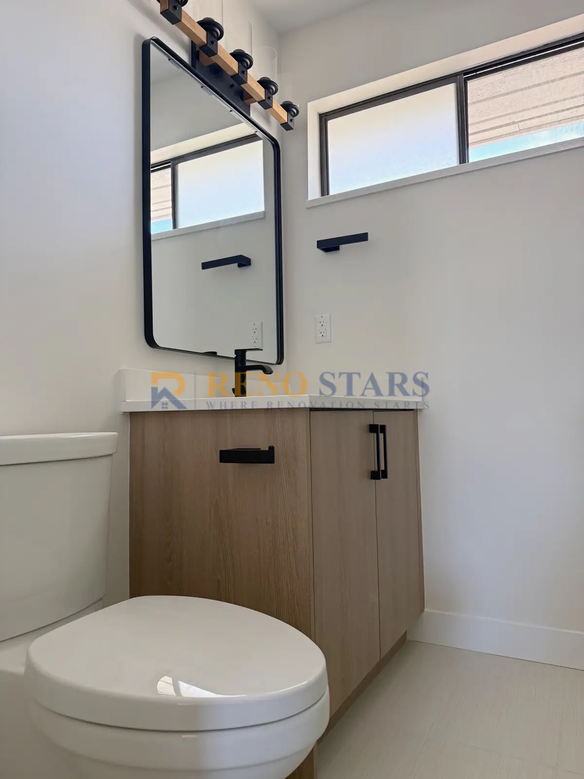 Completed ensuite with new vanity, matte-black fixtures, and marble-look walls